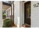 Exterior of white brick townhouse featuring black front door with glass panes, and manicured landscaping at 92 Rogers Ne St, Atlanta, GA 30317