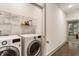 Well-equipped laundry room with front-load washer and dryer, storage shelf and easy access to the rest of the home at 92 Rogers Ne St, Atlanta, GA 30317