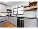 Modern kitchen with grey cabinets, stainless steel appliances, and open shelving at 2047 Seavey Dr, Decatur, GA 30032