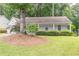 Single-story home with well-maintained front yard and covered porch. Surrounded by mature trees at 4307 Windward Ln, Norcross, GA 30093