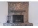 Close-up of a stone fireplace with a wooden mantel and traditional black fire screen at 4307 Windward Ln, Norcross, GA 30093