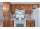 Classic kitchen showcasing ample wood cabinetry, a mosaic backsplash, and a white gas range at 4307 Windward Ln, Norcross, GA 30093