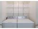 Convenient laundry area with washer, dryer, and wire shelving for organization at 4307 Windward Ln, Norcross, GA 30093