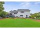 Spacious backyard featuring a well-maintained lawn, mature trees, and a charming deck with outdoor seating at 7108 Hummingbird Ln, Winston, GA 30187