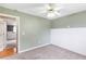Bedroom with chair railing, ceiling fan, neutral color palette, and plush carpet at 7108 Hummingbird Ln, Winston, GA 30187
