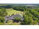 Aerial view featuring the clubhouse and golf course, surrounded by lush trees and well-maintained green spaces at 8430 Merion Drive, Duluth, GA 30097
