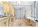 Bright bathroom featuring custom cabinetry, marble countertops, and a luxurious soaking tub with tiled accents at 8430 Merion Drive, Duluth, GA 30097