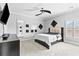 Stylish bedroom featuring sleek furniture, a modern ceiling fan, and abundant natural light from a nearby window at 8430 Merion Drive, Duluth, GA 30097