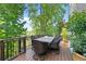 Outdoor dining deck with a large table and seating for six, surrounded by lush greenery and natural light at 8430 Merion Drive, Duluth, GA 30097