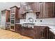 Elegant kitchen features stainless steel appliances, granite countertops, and custom dark wood cabinetry at 8430 Merion Drive, Duluth, GA 30097