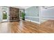 Bright living room featuring a stone fireplace, hardwood floors, and large windows at 8430 Merion Drive, Duluth, GA 30097