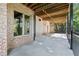Covered patio with exposed wood ceiling, providing a stylish outdoor space with brick accents at 8430 Merion Drive, Duluth, GA 30097