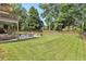 Enjoy this sprawling backyard with a manicured lawn, mature trees, and inviting patio area at 1006 Kingsbridge Vw, Powder Springs, GA 30127
