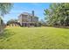 Extensive backyard with a lush lawn, patio seating area, and mature trees, providing a serene outdoor environment at 1006 Kingsbridge Vw, Powder Springs, GA 30127