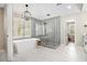 Bright modern bathroom with soaking tub, glass shower, and tile floors at 1006 Kingsbridge Vw, Powder Springs, GA 30127