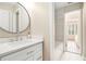 Modern bathroom featuring a large round mirror, and a vanity with white cabinets and a countertop at 1006 Kingsbridge Vw, Powder Springs, GA 30127