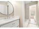 Bright bathroom featuring a modern vanity with a round mirror, and access to the tiled shower and bathtub at 1006 Kingsbridge Vw, Powder Springs, GA 30127