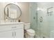 Modern bathroom features white vanity, toilet, and glass shower with white tiled walls at 1006 Kingsbridge Vw, Powder Springs, GA 30127