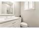 Bright bathroom features white vanity, toilet and a shower with white tiles at 1006 Kingsbridge Vw, Powder Springs, GA 30127