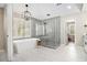 Elegant bathroom featuring a freestanding tub, large glass shower, and modern chandelier at 1006 Kingsbridge Vw, Powder Springs, GA 30127