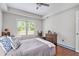 Relaxing bedroom with a ceiling fan, hardwood floors, and a large window offering natural light at 1006 Kingsbridge Vw, Powder Springs, GA 30127