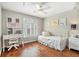 Well-lit bedroom with hardwood floors, a ceiling fan, a desk area and a cozy bed at 1006 Kingsbridge Vw, Powder Springs, GA 30127