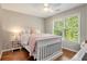 Charming bedroom featuring hardwood floors, a ceiling fan, and a large window with natural light at 1006 Kingsbridge Vw, Powder Springs, GA 30127