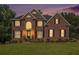 Charming two-story brick home featuring a well-manicured lawn and a symmetrical design during sunset at 1006 Kingsbridge Vw, Powder Springs, GA 30127