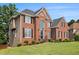 Elegant brick home featuring a well-manicured front lawn, mature landscaping, and a welcoming entrance at 1006 Kingsbridge Vw, Powder Springs, GA 30127