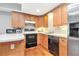 Functional kitchen with wood cabinets, black appliances, and counter space for meal preparation at 1006 Kingsbridge Vw, Powder Springs, GA 30127