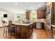 Gourmet kitchen has wood cabinets, granite counters, stainless appliances and island with cooktop at 1006 Kingsbridge Vw, Powder Springs, GA 30127