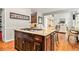 Kitchen island features granite counters and cooktop, open to living area with wood floors at 1006 Kingsbridge Vw, Powder Springs, GA 30127