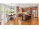 Open eat-in kitchen boasts wood cabinets, granite counters, stainless appliances, and wood floors at 1006 Kingsbridge Vw, Powder Springs, GA 30127