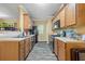Galley-style kitchen with wood cabinets, black appliances, and neutral countertops at 1414 Dolcetto Nw Trce # 14, Kennesaw, GA 30152