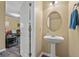 This powder room features a pedestal sink, oval mirror, and is conveniently located near the living area at 1414 Dolcetto Nw Trce # 14, Kennesaw, GA 30152