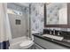 Charming bathroom with floral wallpaper, shower-tub combination, and granite sink top at 764 Stokeswood Se Ave, Atlanta, GA 30316