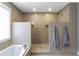 Luxurious bathroom featuring a double shower with intricate tile work and a soaking tub beneath a window at 764 Stokeswood Se Ave, Atlanta, GA 30316