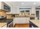Well-lit kitchen showcasing stainless steel appliances, granite countertops, mosaic backsplash, and a gas range at 764 Stokeswood Se Ave, Atlanta, GA 30316