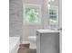 Modern bathroom with marble-look tile, gray vanity, and a window at 1641 Rockcliff Se Pl, Atlanta, GA 30316