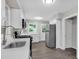 Bright kitchen with stainless steel appliances, white cabinets, and gray wood floors at 1641 Rockcliff Se Pl, Atlanta, GA 30316