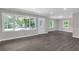 Bright living room with large windows, neutral paint, and modern gray wood floors at 1641 Rockcliff Se Pl, Atlanta, GA 30316