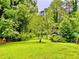 Lush backyard with large green trees, green grass, and an outdoor storage shed at 1968 Don Juan Ln, Decatur, GA 30032