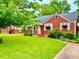 Charming brick home with green lawn and red and white striped awnings at 1968 Don Juan Ln, Decatur, GA 30032