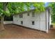 A backyard exterior view of a bright, white brick house with a well manicured mulch bed at 2683 Rockcliff Se Rd, Atlanta, GA 30316
