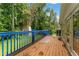 Wood deck with blue railings offering a view of the green backyard and mature trees, great for relaxation at 137 Trickum Hills Dr, Woodstock, GA 30188