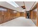 Unfinished basement with paneled walls, carpet, and drop ceiling, providing ample storage and utility space at 137 Trickum Hills Dr, Woodstock, GA 30188