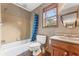 Functional bathroom features a tub-shower combo and single sink vanity with a wood frame window for natural light at 137 Trickum Hills Dr, Woodstock, GA 30188