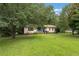 Cozy home featuring a green lawn and mature trees, with blue painted railings on the front steps and porch at 137 Trickum Hills Dr, Woodstock, GA 30188