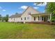 Spacious backyard view of the house with a covered patio, brick foundation, and an expansive lawn at 2333 Old Newnan Rd, Carrollton, GA 30116