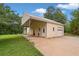 Detached garage with an attached carport and a long driveway surrounded by a verdant lawn at 2333 Old Newnan Rd, Carrollton, GA 30116
